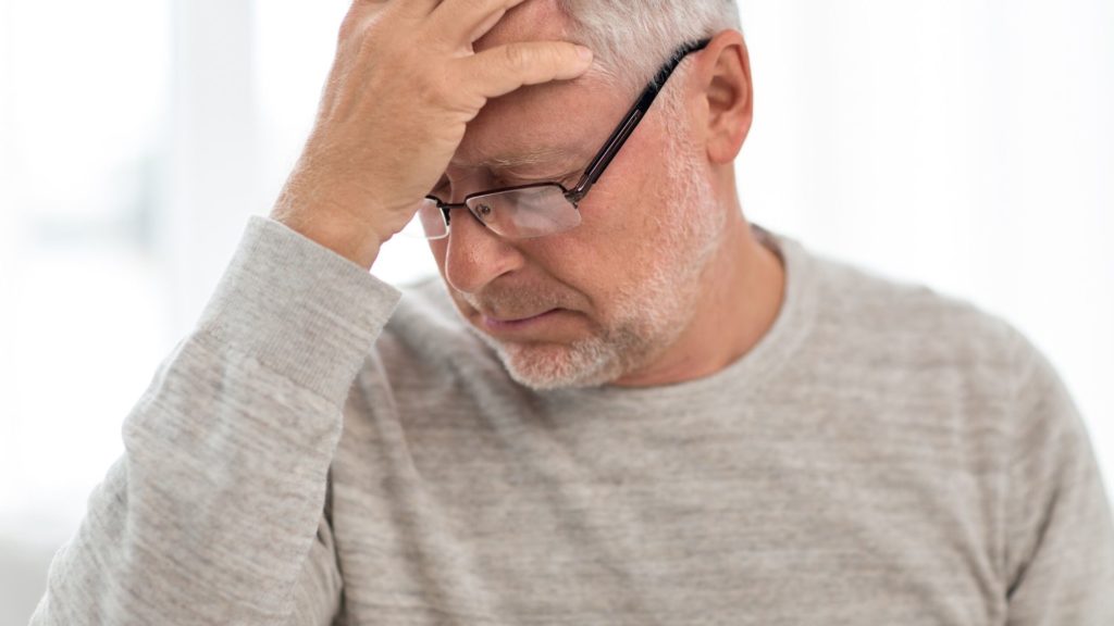 An older retired man looking stressed